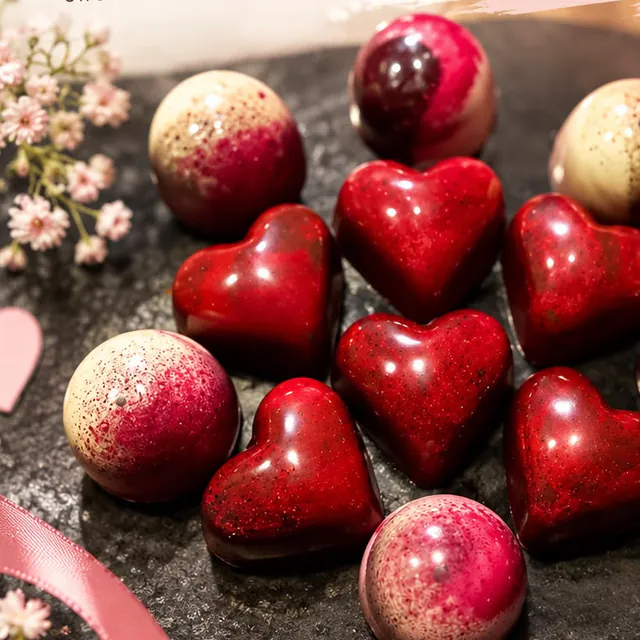 Bombones en forma de corazón y domos en tonos rojos y rosados